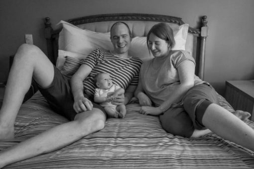 Mum and Dad and baby daughter on the big bed