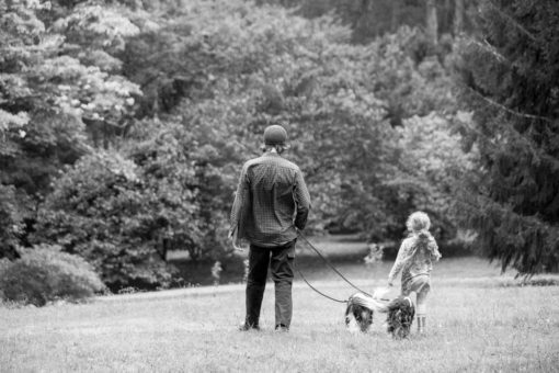 Father and daughter walking together with the family dogs in a park in the Dandenong Ranges